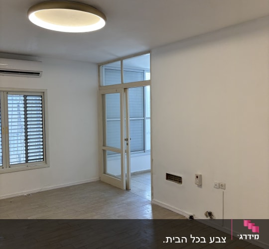 חדר צבוע עם רצפת עץ ותאורה עגולה בתקרה
